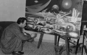 Guerino Gambella, pittore tarquiniese, dipinge un paesaggio spaziale con forme metafisiche e colori visionari.