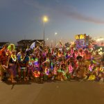 Gruppo mascherato con costumi colorati durante la sfilata del Carnevale estivo 2025 a Tarquinia Lido