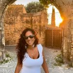 Elena Murgia a Tarquinia durante le riprese del video promozionale, con scorcio del centro storico sullo sfondo.