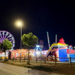 Panoramica del Luna Park di Tarquinia Lido con ruota panoramica e attrazioni illuminate, meta di svago estivo sul litorale.