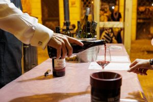 Sommelier versa un calice di vino rosso durante le degustazioni al Divino Etrusco 2025 a Tarquinia.