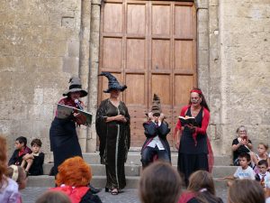 Figuranti con cappello parlante e libri in mano davanti alla chiesa di Tarquinia per la cerimonia di smistamento durante Back to Hogwarts.
