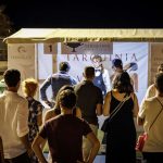 Persone in fila a uno stand di degustazione vino al DiVino Etrusco 2025 a Tarquinia