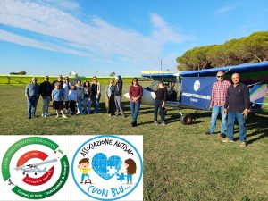 Gruppo di ragazzi e adulti dell’Associazione Autismo Cuori Blu di Tarquinia davanti a ultraleggero al Campo di Volo in località San Giorgio