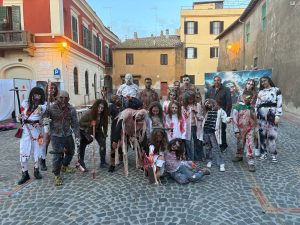 Gruppo di figuranti in costume horror nel centro storico di Tarquinia durante la festa di Halloween 2025.