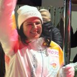 Erika Biagioni tedofora saluta il pubblico con la fiaccola olimpica Milano Cortina 2026 a Tarquinia